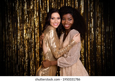 Photo Of Two Charming Ladies Embrace Look Camera Toothy Shiny Smile Wear Glossy Dresses Isolated Tinsel Background