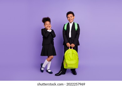 Photo Of Two Cheerful African People Schoolchildren Boy Help Girl Carry Bag Wear Uniform Isolated Violet Color Background