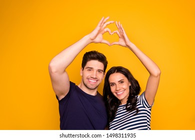 Photo Of Two Cheerful Nice Cute People Showing Heart That Symbolizes Their Feeling About Each Other While Isolated With Vivid Background