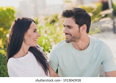 Photo of two flirty people communicate look each other relax wear casual clothes in garden park outside