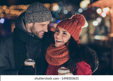 Photo of two funny people pair with hot beverage in hands spending x-mas evening together having best leisure time wearing warm coats knitted caps and scarfs - Powered by Shutterstock