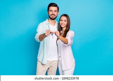 Photo of two persons hold hands together keys from new house toothy smile isolated on blue color background