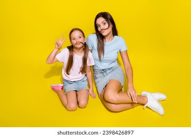 Photo of two positive girl playing game with fake curls mustache make v sign isolated over vivid color background