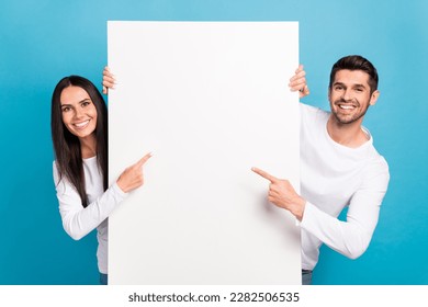 Photo of two positive nice people indicate finger empty space proposition isolated on blue color background - Shutterstock ID 2282506535