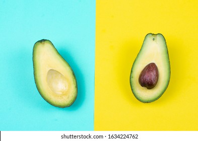 Photo of two slices natural bio organic green avocado on the colorful background solid yellow and solid cyan background 
