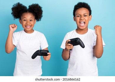 Photo Of Two Small African Kids Happy Positive Smile Play Video Game Win Lucky Champion Isolated Over Blue Color Background