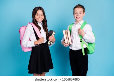 Photo of two small girl boy schoolchildren brother sister classmates hold books walk library study year finishing wear backpack white shirt black pants dress isolated blue color background - Powered by Shutterstock