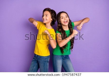Photo of two trendy brunette cheerful children dance dream funky mood isolated on purple color background