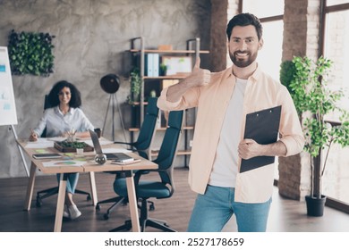 Photo of two young colleagues clipboard thumb up loft interior office business center indoors - Powered by Shutterstock