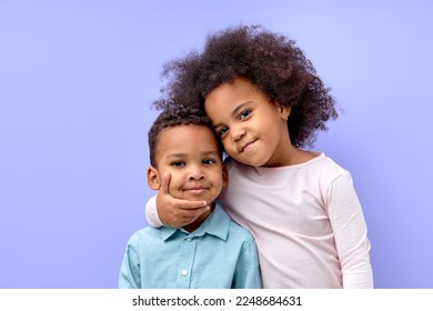 Photo of two young little black kids happy positive smile embrace family together isolated over violet purple color background. beautiful cildren in casual outfit love each other, hugging - Shutterstock ID 2248684631