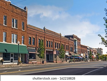 A Photo Of A Typical Small Town Main Street In The United States Of America. Features Old Brick Buildings With Specialty Shops And Restaurants. Decorated With Autumn Decor. 