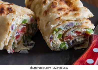A photo of Ugandan popular street food known as 'Ugandan rolex'. It is a omelette wrapped in a chapati. Extreme close up with selective focus.