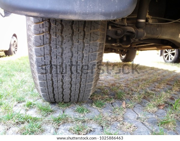 Photo of under the car\
in car park, tire