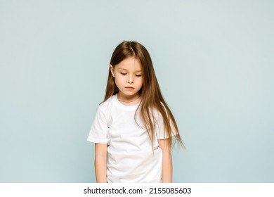 Photo of unhappy sad upset little girl feeling bored offended isolated on blue background