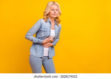 Photo Of Unhappy Sad Upset Old Woman Pain Bad Mood Stomach Hands Isolated On Yellow Color Background