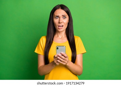 Photo Of Unhappy Scared Young Woman Hold Phone Dislike Reaction Addicted Blogger Isolated On Bright Green Color Background