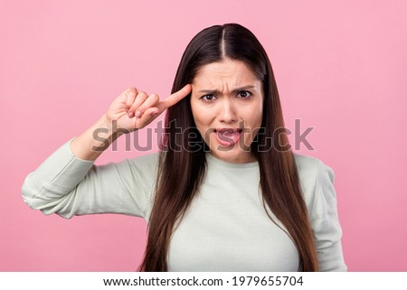 Photo of unhappy stressed young woman point finger head tease accuse isolated on pink color background