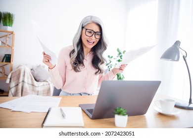 Photo Of Unhappy Upset Angry Old Woman Look Laptop Sit Table Hold Documents Deadline Indoors Inside House Home