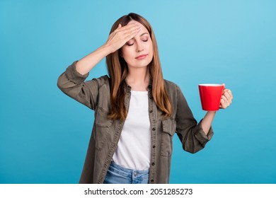 Photo Of Unhappy Upset Mature Woman Hold Cup Of Tea Hold Hand Forehead Fever Isolated On Blue Color Background