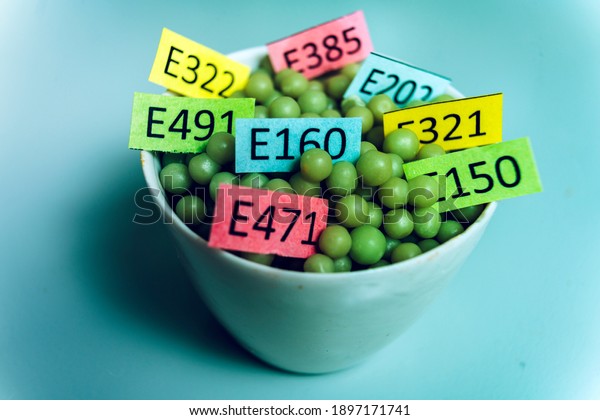 Photo unhealthy food: chemical additives\
in the form of granules with colored\
labels.