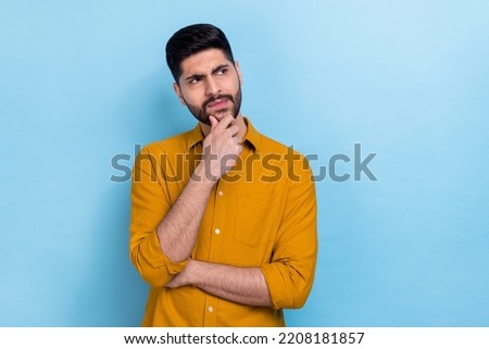 Photo of unsure beard young guy look promotion wear brown shirt isolated on blue color background