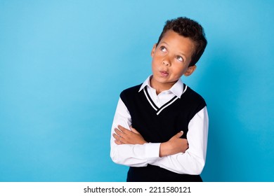 Photo Of Unsure Dreamy Little Guy Dressed Black Vest Arms Folded Looking Empty Space Isolated Blue Color Background