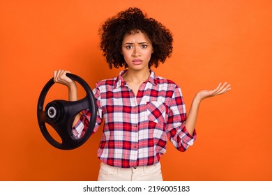 Photo Of Unsure Uncertain Young Woman Wear Plaid Shirt Not Knowing How Control Car Isolated Orange Color Background