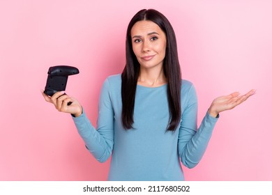 Photo Of Unsure Woman Wear Blue Shirt Holding Playstation Shrugging Shoulders Isolated Pink Color Background