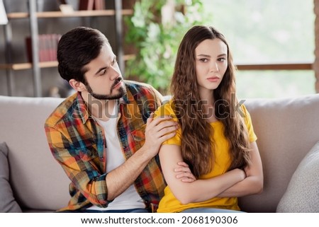 Photo of upset couple bearded man try comfort offended girlfriend wear casual clothes sit couch home indoors