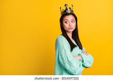 Photo of upset moody lady wear turquoise sweater diadem arms crossed looking back empty space isolated yellow color background - Powered by Shutterstock