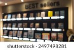 Photo of Variety of best sellers books for sale at book store displayed at shelf. blurred background.