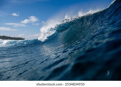 In the photo, vibrant turquoise waves crash against the sun-kissed shores of Telo Island, Indonesia. A lone surfer, silhouetted against the setting sun, rides a majestic wave with effortless grace. - Powered by Shutterstock