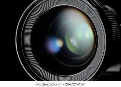 Photo or video camera lens with light reflections close-up on the black background.