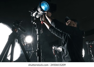 Photo Video Studio Equipment Preparation by Caucasian Lighting Technician - Powered by Shutterstock