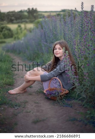 Photo of a village girl in a summer meadow.