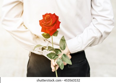 Photo Is Vintage Of Man Holding A Red Rose Behind His Back  For His Woman