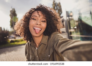 Photo of wavy hairdo funny carefree dark skin person make selfie show tongue out have good mood weekend outdoors - Powered by Shutterstock