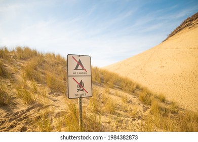 In The Photo We See The Desert. Mountainous Terrain. Grass Scorched By The Sun Grows On The Side Of The Mountain. Prohibitory Signs. No People. Color Image.