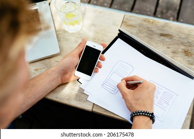 Photo Of A Web Designer Drawing A Blueprint Of A New Mobile Application