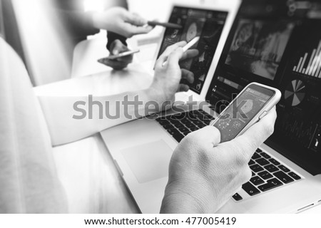 Photo website graphic designer hand working with his team make new project in studio.Modern laptop extend screen digital tablet smart phone on wood table, black white