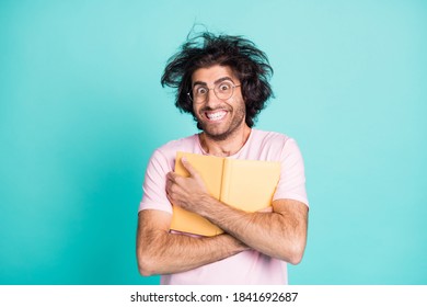 Photo Of Weird Hairstyle Satisfied Man Arms Hold Cuddle Book To Chest Toothy Smile Isolated On Turquoise Color Background