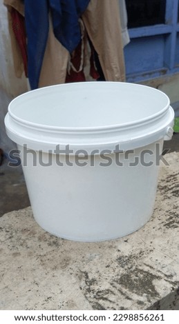 Photo of a white bucket object on top of a wall, taken from a close-up angle