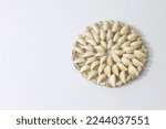 Photo of white table decorated with magnificent coaster white background and wall. Photo of a vintage coaster handmade from seashells.