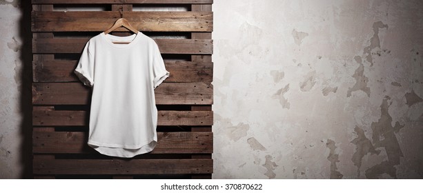 Photo White Tshirt  Hanging In Front Of Concrete Wall. Wide