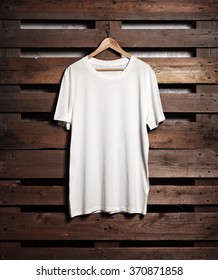 Photo Of White Tshirt Hanging On Wood Background