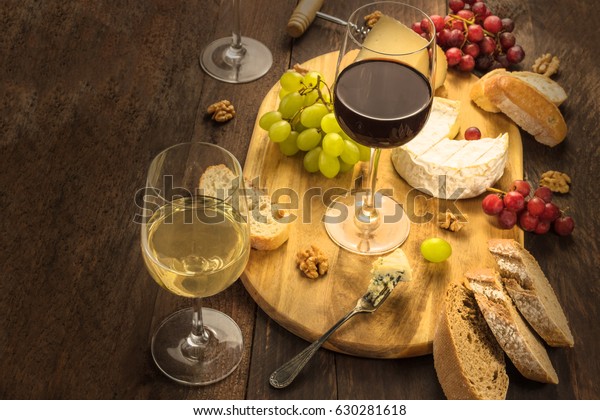 A photo of a\
wine and cheese tasting, with bread, grapes, and wine accessories,\
as well as a place for text