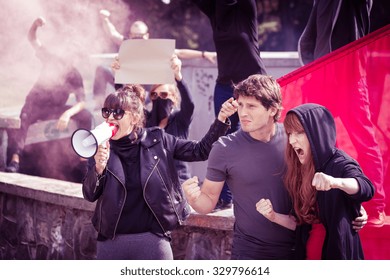 Photo of woman with megaphone and protesting couple