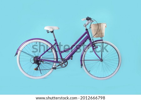 Photo of woman retro vintage bicycle used for town transportation with brown basked isolated over blue color background.