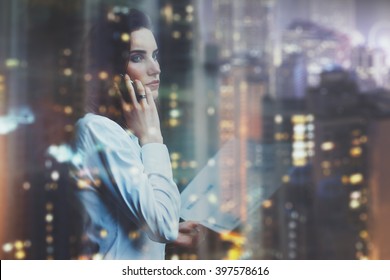 Photo woman wearing white shirt, talking smartphone and holding business documents in hands. Open space loft office. Panoramic windows, night city background. Horizontal mockup, bokeh. Film effect - Shutterstock ID 397578616