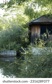 Photo of a wooden house that has a pond in front of it. This was taken at the Botanical garden in Niagara Falls, Canada